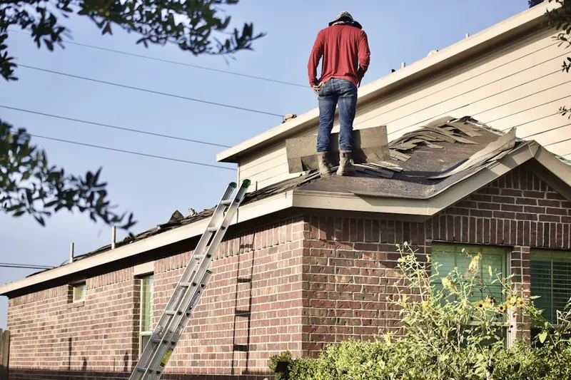 Professional roofer working on a residential roof in Celina